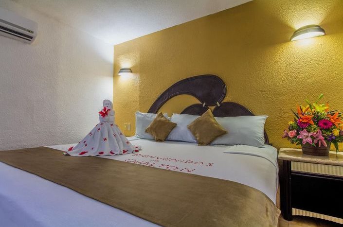 Hotel Qualton Ixtapa Habitación estándar con vista a los jardines, equipada con una cama King size, ideal para parejas que viajan de vacaciones en Ixtapa Zihuatanejo